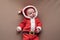 Newborn girl dressed in santa claus costume looking at camera with confused face.