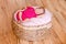 Newborn girl in pink bodysuit barefoot lies in round crib and sleeps