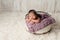 Newborn Girl Sleeping in Wooden Bucket