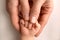 A newborn holds on to mom& x27;s, dad& x27;s finger. Hands of parents and baby close up. A child trusts and holds her tight