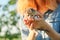 Newborn kitten in the hands of teenage girl, background nature sky garden