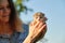 Newborn kitten in the hands of teenage girl, background nature sky garden