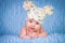 Newborn in knitted cap on a blue background.