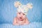 Newborn in knitted cap on a blue background.