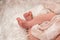 A newborn in a knitted jumpsuit in beige background. concept of happiness place under the text