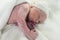 newborn in the postpartum crib still covered in vernix caseosa and with the baby hat for the first time