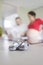 Newborn shoes on a kitchen table while expecting couple standing unfocussed in the background