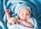 Newborn sleep at first days of life. Portrait of new born baby one week old with cute soft toy in crib in cloth background