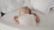 Newborn sleeps in a cot in a bright room. Little girl resting after feeding