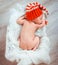 Newborn sleeps in santa hat