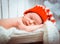 Newborn sleeps in santa hat