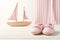 Newborn striped baby shoes and toy boat on wooden background