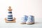 Newborn striped baby shoes and toy lighthouse on wooden background