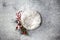 Newborn winter background - round cream bowl with CHristmas red berries and snow covered branches  garland on white backdrop