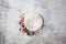 Newborn winter background - round cream bowl with CHristmas red berries and snow covered branches  garland on white backdrop