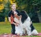 Newfoundland dog plays with man and woman