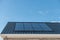 Newly build house in the Netherlands with solar panels attached on the roof against a sunny sky Close up of new building