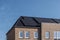 Newly build houses with solar panels attached on the roof against a sunny sky Close up of new building with black solar