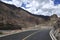 A newly built flat asphalt road leads to the foot of the mountain