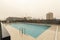 A newly built rectangular community pool in a new area of the city on a torrential rainy day