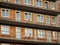 A newly built red brick block with plastic windows covered with foil, gray concrete balconies and wooden makeshift balustrades