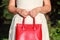 Newly engaged woman holding red leather bag