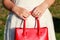 Newly engaged woman holding red leather bag