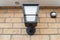 Newly installed multi-colour outdoor smart light seen together with a wireless PIR detector.