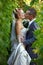 Newly-married couple kisses in a vineyard