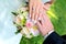 Newly married couple shows his rings on the bridal bouquet