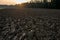 Newly ploughed field in spring time during sunset