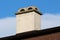 Newly renovated suburban family house chimney with small openings on top waiting to be repainted
