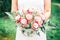 Newly Wed Woman Holding her Bridal Bouquet in a Green Garden