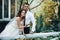 newlywed couple posing near rustic fountain