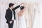 Newlywed cute bride and groom hold hand togher dancing in fitting room