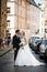 Newlywed, happy man and wife posing in old city street