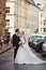 Newlywed, happy man and wife posing in old city street