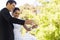 Newlywed toasting champagne flutes besides cake at park