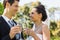 Newlywed toasting champagne flutes at park