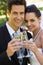 Newlywed toasting champagne flutes at park