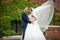 Newlywed valentynes hugging in a park vines background wind blow