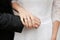 The newlyweds, the bride and groom hold hands with wedding rings