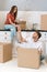 Newlyweds with cardboard boxes moving in new home