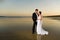 Newlyweds on a deserted beach at sunset