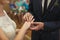 Newlyweds exchange rings, groom puts the ring on the bride`s hand in marriage registry office.