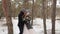 Newlyweds groom and bride hug kiss and warm each other in snowy pine forest during snowfall in slow motion. . Young