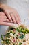 Newlyweds hands with engagement rings near bridal bouquet