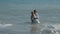 Newlyweds have fun in the ocean