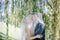 Newlyweds kiss under a veil on background willow