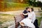 Newlyweds kissing at bench in park.